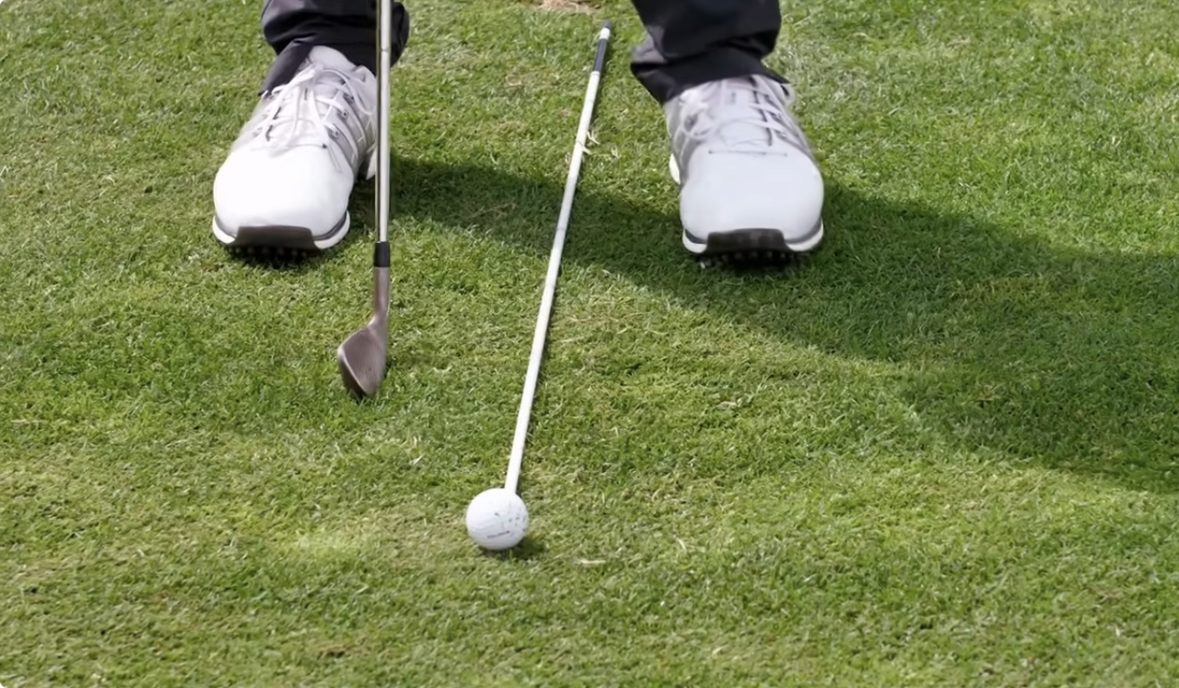 Alignment stick showing ball position in pro golfers stance